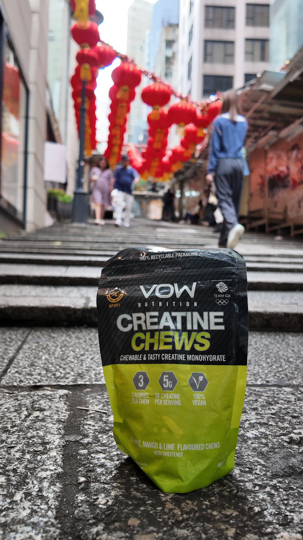 VOW Apple, Mango and Lime Creatine Chews on stone steps with red lanterns behind