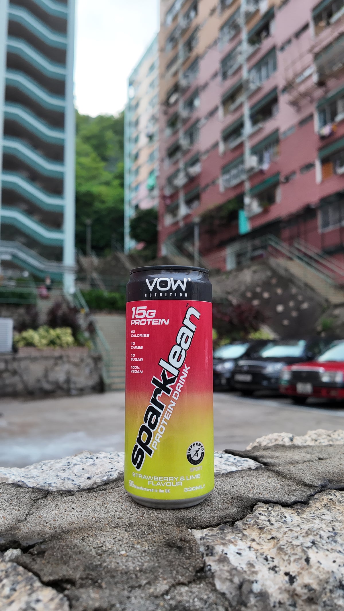 Sparklean 草莓青檸味蛋白飲，背景是香港住宅與街道